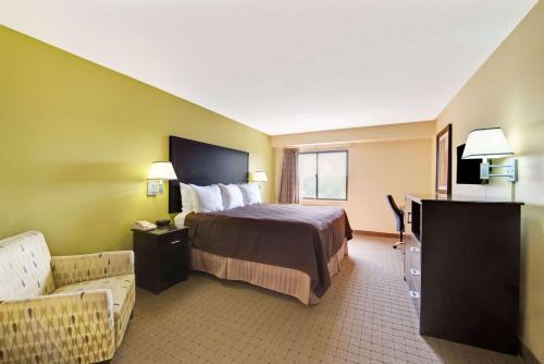 um quarto de hotel com uma cama e um sofá em Days Inn & Suites by Wyndham DeSoto em DeSoto