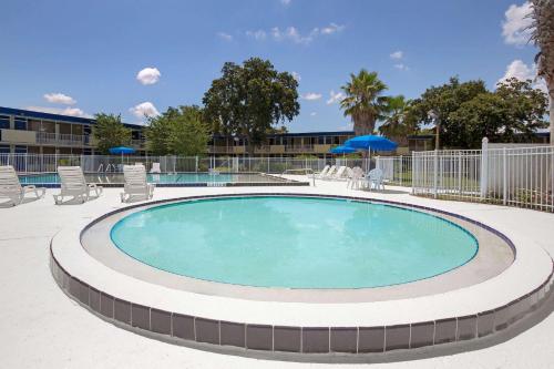 a swimming pool with a pool table and chairs at One Way Maingate in Kissimmee