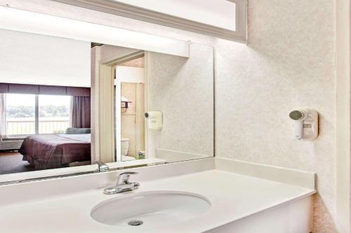 a bathroom with a sink and a mirror at Days Inn by Wyndham Forrest City in Forrest City