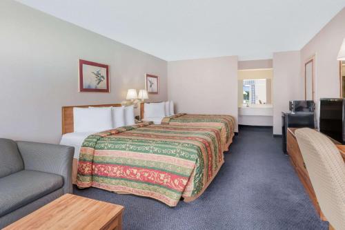 a hotel room with a bed and a couch at Days Inn by Wyndham Seguin TX in Seguin