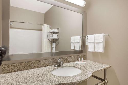 y baño con lavabo, espejo y toallas. en Days Inn & Suites by Wyndham Marquez, en Marquez