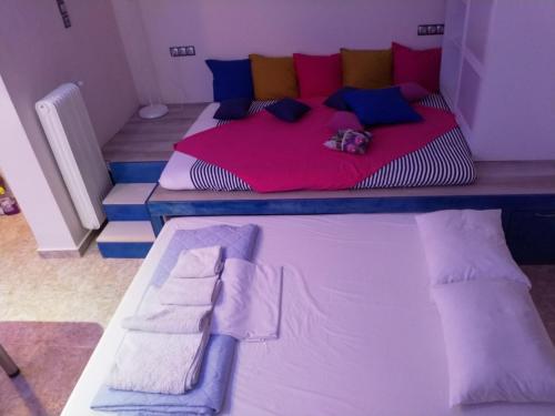アテネにあるCosy apartment Acropolis Point-3のベッドルーム1室(大型ベッド1台、カラフルな枕付)