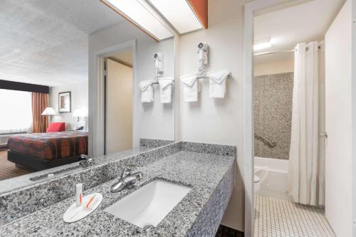 a bathroom with a sink in a hotel room at Days Inn by Wyndham Pearl/Jackson Airport in Pearl