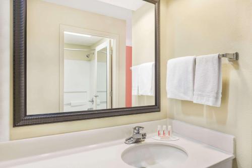 a bathroom with a sink and a mirror at Days Inn by Wyndham Shallotte in Shallotte