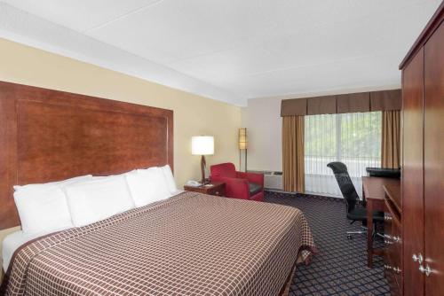 ein Hotelzimmer mit einem Bett und einem Schreibtisch in der Unterkunft Days Inn by Wyndham Geneva/Finger Lakes in Geneva