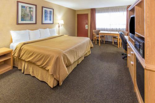 Habitación de hotel con cama y escritorio en Days Inn by Wyndham Black Bear en Salem