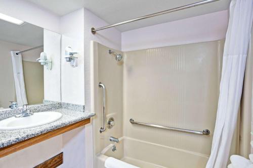 a bathroom with a sink and a shower at Days Inn & Suites by Wyndham Fullerton in Fullerton