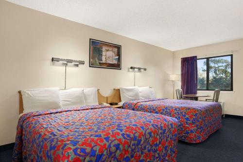 a hotel room with two beds and a window at Days Inn by Wyndham Buena Park in Buena Park