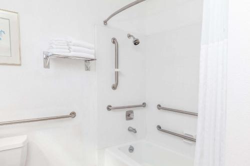 a bathroom with a shower and a toilet at Days Inn & Suites by Wyndham Sunnyvale in Sunnyvale