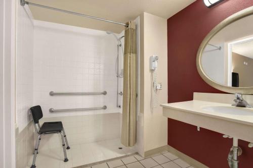 a bathroom with a shower and a sink and a mirror at Days Inn by Wyndham Buena Park in Buena Park