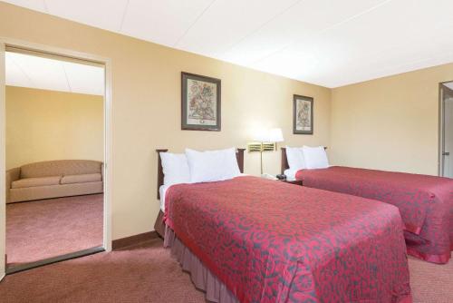 a hotel room with two beds and a mirror at Days Inn by Wyndham Hagerstown I-70 in Hagerstown