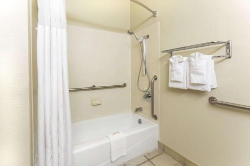 a bathroom with a tub and a shower with a shower curtain at Days Inn by Wyndham Colorado Springs Airport in Colorado Springs