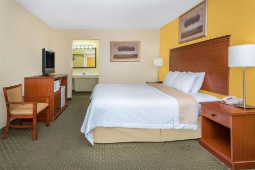 a hotel room with a bed and a desk and a television at Alamo Inn in Buffalo