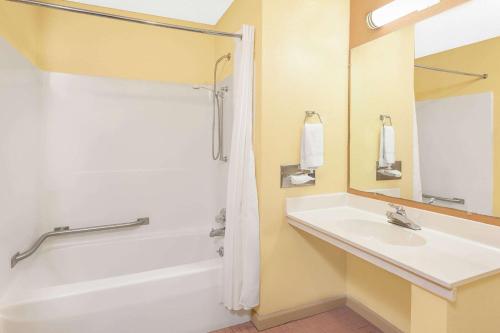 uma casa de banho com um lavatório e um chuveiro em Days Inn & Suites by Wyndham Kalamazoo em Kalamazoo