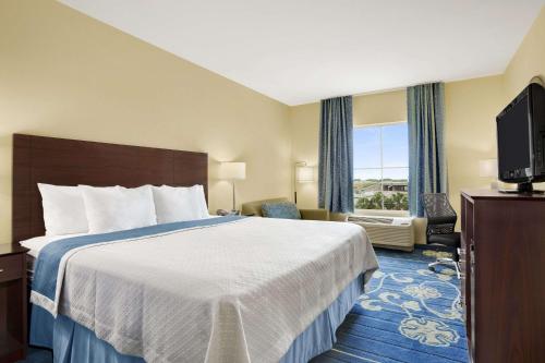 una camera con letto e TV a schermo piatto di Days Inn by Wyndham Victoria a Victoria