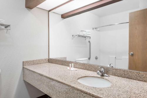 y baño con lavabo y espejo. en Days Inn & Suites by Wyndham Casey, en Casey