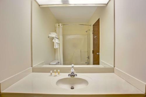 a bathroom with a sink and a mirror at Days Inn & Suites by Wyndham Hickory in Hickory