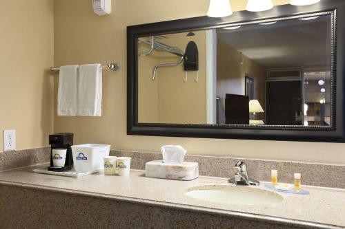 a bathroom counter with a sink and a mirror at Days Inn by Wyndham Henryetta in Henryetta