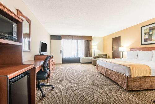 a hotel room with a bed and a desk at Days Inn by Wyndham Altus in Altus
