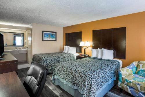 a hotel room with two beds and a television at Days Inn by Wyndham Sarasota Bay in Sarasota