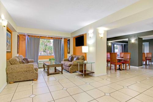 a living room with couches and a dining room at Days Inn & Suites by Wyndham Tampa - Ybor City in Tampa