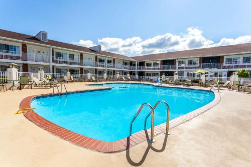 a large pool in front of a hotel at Days Inn & Suites by Wyndham Roseville/Detroit Area in Roseville