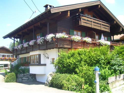 ein Haus mit Blumenkästen an der Seite in der Unterkunft "Ferienwohnung Ess" - Annehmlichkeiten von 4-Sterne Familien-und Wellnesshotel Viktoria können mitbenutzt werden in Oberstdorf