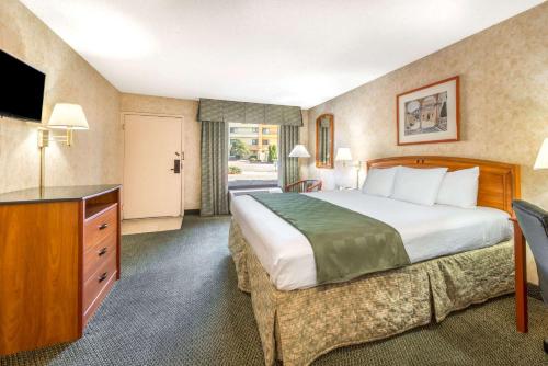 a hotel room with a bed and a television at Days Inn & Suites by Wyndham Albuquerque North in Albuquerque