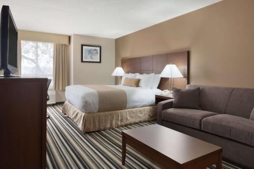 a hotel room with a bed and a couch at Days Inn by Wyndham Dalhousie in Dalhousie