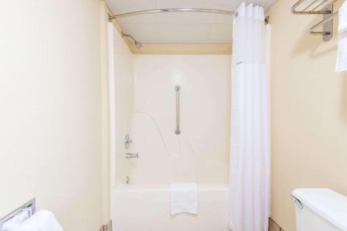 a bathroom with a shower and a white tub at Days Inn by Wyndham Altus in Altus