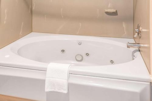 a white bath tub in a bathroom with a towel at Days Inn by Wyndham Tiffin in Tiffin
