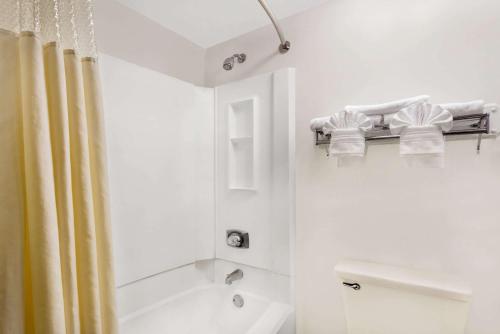 印第安纳波利斯Days Inn by Wyndham Indianapolis Northeast的带浴缸和淋浴的白色浴室