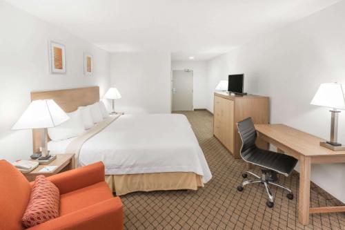 Habitación de hotel con cama y escritorio en Days Inn by Wyndham Biloxi Beach, en Biloxi