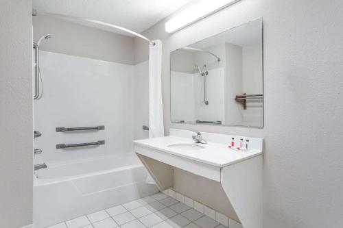 a white bathroom with a sink and a shower at Days Inn by Wyndham Lugoff in Lugoff
