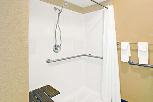 La salle de bains est pourvue d'une douche avec rideau de douche blanc. dans l'établissement Days Inn by Wyndham Boerne, à Boerne