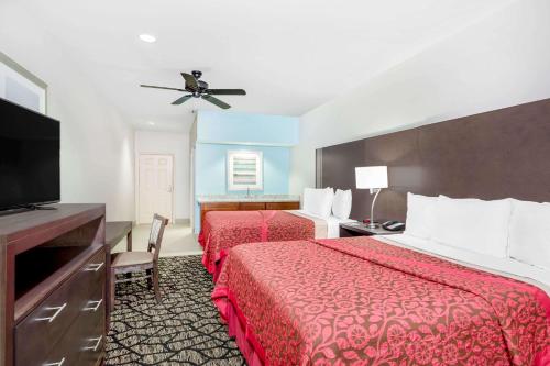 een hotelkamer met 2 bedden en een flatscreen-tv bij Days Inn & Suites by Wyndham Madisonville in Madisonville