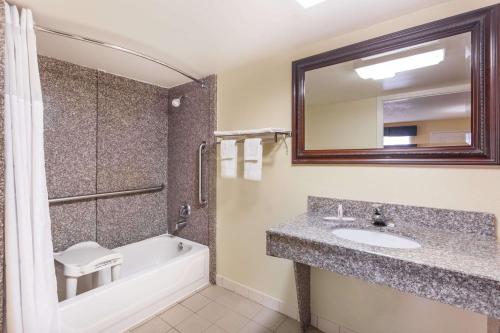 华纳罗宾斯Days Inn & Suites by Wyndham Warner Robins Near Robins AFB的带水槽、浴缸和镜子的浴室