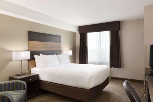 Ένα ή περισσότερα κρεβάτια σε δωμάτιο στο Days Inn & Suites by Wyndham Lindsay