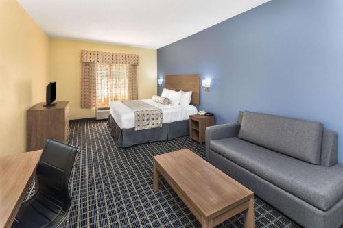 a hotel room with a bed and a couch at Days Inn & Suites by Wyndham Union City in Union City