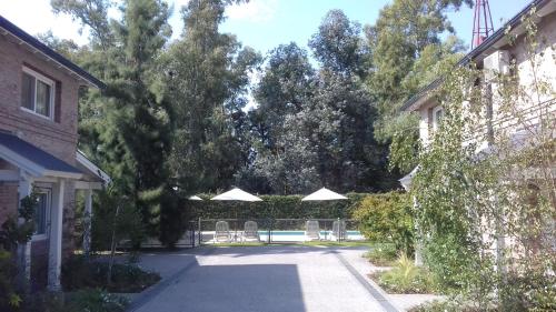 a patio with chairs and umbrellas in a yard at Descanso del Molino in Luján