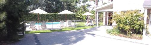a fence with chairs and a pool in a yard at Descanso del Molino in Luján