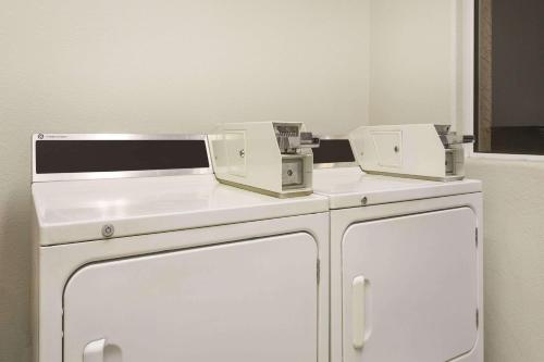 dos máquinas sentadas en la parte superior de un armario blanco en un baño en Days Inn by Wyndham Bullhead City, en Bullhead City