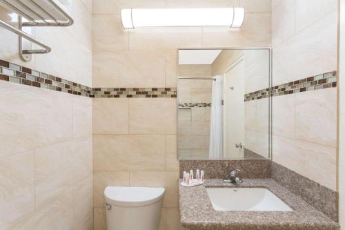 a bathroom with a sink, toilet and bathtub at Days Inn by Wyndham Indio in Indio