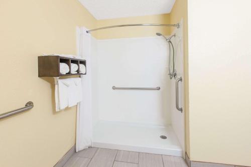 a bathroom with a shower and a tub at Days Inn by Wyndham Miami in Miami