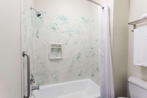 a bathroom with a shower with a shower curtain at Days Inn & Suites by Wyndham South Gate in South Gate