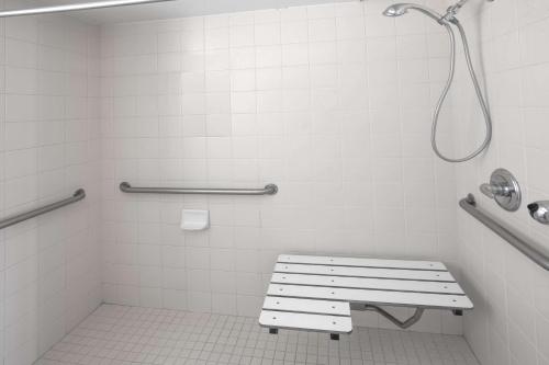 a white bathroom with a bench and a shower at Days Inn by Wyndham Oroville in Oroville