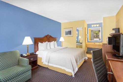 um quarto de hotel com uma cama e uma cadeira em Days Inn by Wyndham Mocksville em Mocksville