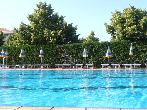 a swimming pool with umbrellas and tables and chairs at Residence Aurora Wellness & Spa in Albenga