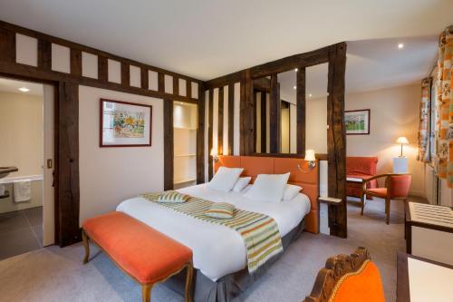 Postel nebo postele na pokoji v ubytování Hotel Restaurant Le Dauphin et Le Spa du Prieuré