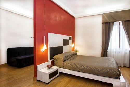 ein kleines Schlafzimmer mit einem Bett und einem Sofa in der Unterkunft Agriturismo Il Falco in Velletri